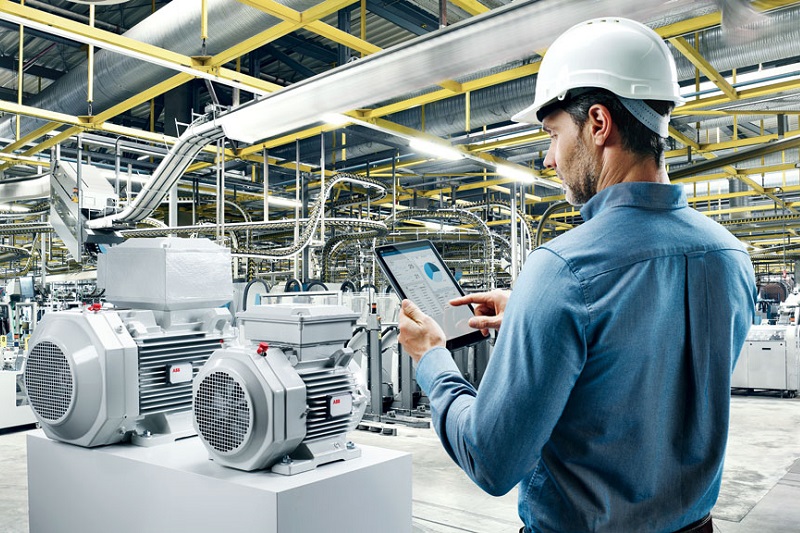 Engenheiro com tablet operando motores ABB em ambiente industrial